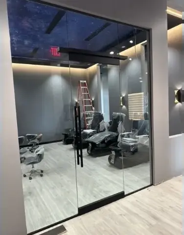 Frameless glass room enclosure with a glass door inside a modern interior
